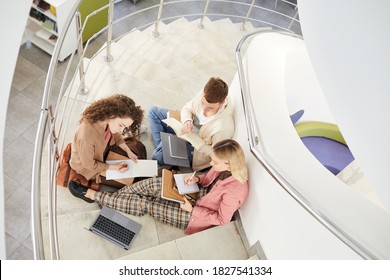 Top Down View At Group Of Students Sitting On Stairs In College And Working On Homework Together, Copy Space