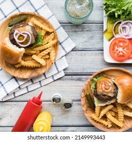 Top Down View Of Hamburger Sliders On Small Plates Served With French Fries.