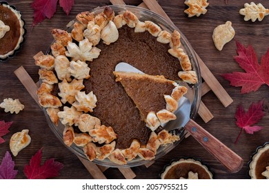 Top Down View Of A Homemade Pumpkin Pie With One Slice Being Removed.