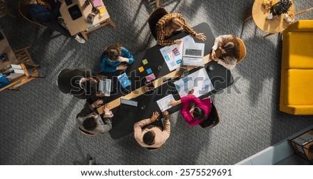 Top Down View: Innovative Teamwork at Office Table. Diverse Professionals Collaborate Using Laptops and Tablets, Strategizing and Brainstorming Ideas for Creative Business Problem Solving