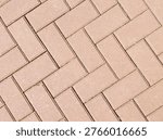 Top down view of interlocking concrete pavers on a walkway background.