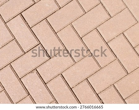 Top down view of interlocking concrete pavers on a walkway background.