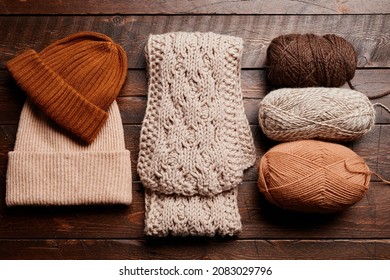 Top Down View Of Knit Scarf And Hat With Wool On Dark Wooden Background, Knitting And Hobby, Copy Space
