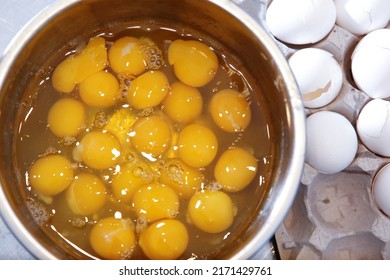 A top down view of a large bowl of raw eggs.