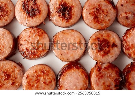 A top down view of a layer of sauteed kielbasa slices, as a background.