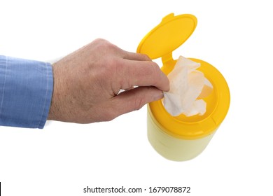 Top Down View Of A Male Hand Removing A Disinfecting Wipe From A Container Isolated On White