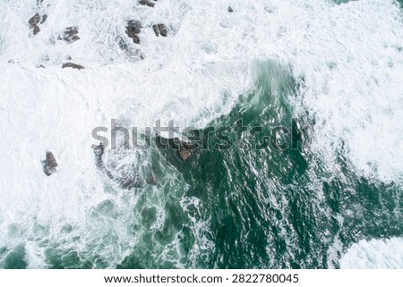 Top down view of massive waves hitting rocks The Concept of unstoppable force