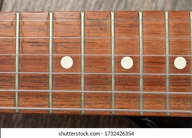 A Top Down View Of A Neck Of An Electric Guitar, As A Background.