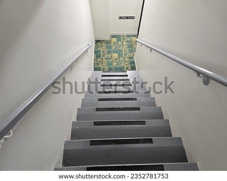 A top down view of an old staircase with grips on the edge of each step to prevent slipping.