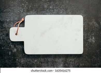 Top Down View On An Empty White Marble Cutting Board.