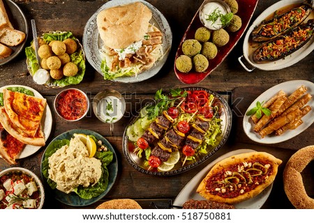 Top down view on freshly prepared delicious varieties of Mediterranean dishes with bread on wooden table