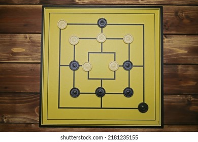 Top Down View On Gameboard With Black And White Pieces Of Strategy Game For Two People - Nine Men's Morris Or Mills