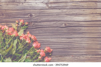 Top down view on large rose bundle in bottom half over weathered wooden table surface with copy space