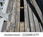 A top down view on an old back deck with boards that are being removed and replaced to ensure it is safe to use.