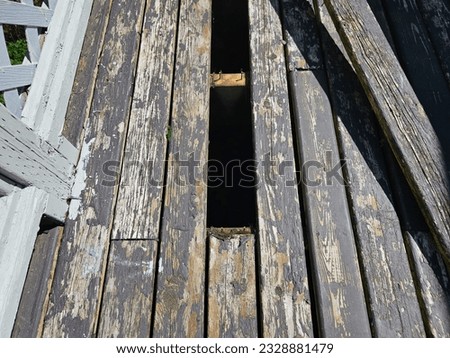 A top down view on an old back deck with boards that are being removed and replaced to ensure it is safe to use.