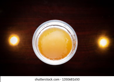 Top Down View On A Round Glass Of Beer On A Wooden Bar, Between Two Spotlights, In A Happy Hour Concept