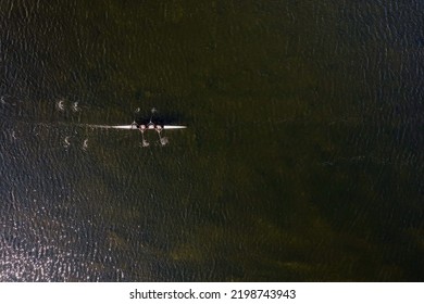 Top Down View On A Rowing Team In A Small River. Water Sport And Workout Concept.