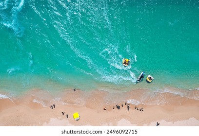 Top down view of outdoor enthusiasts enjoying jet skiing, banana boat riding and other water sports at a beautiful beach on Jibei Island, a famous tourist destination in Baisha, Penghu County, Taiwan - Powered by Shutterstock