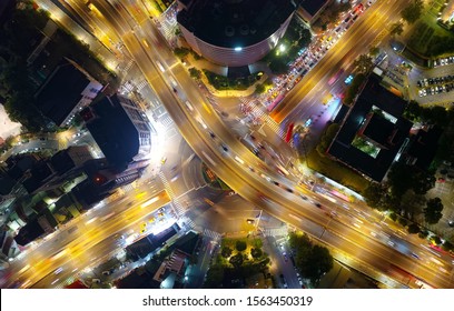Top down view over the circular interchange of Keelung Road & Roosevelt Avenue, with the elevated expressway flying over the roundabout & light trails of cars dashing on the streets, in Taipei, Taiwan