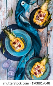 Top Down View Of Pineapple Boats Filled With A Creamy Tropical Chicken Salad On Blue Plates