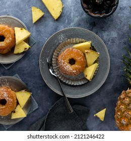 Top Down View Of Pineapple Upside Down Cakes Served With Pineapple Wedges.