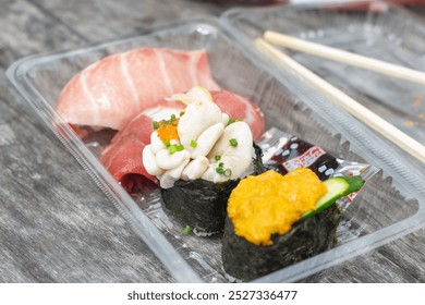 Top down view of a plastic box of assorted sushi with wooden chopsticks on table. Fukuoka, Japan - Powered by Shutterstock