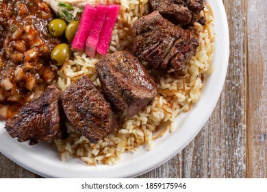 A Top Down View Of A Plate Of Beef Shish Kabob.