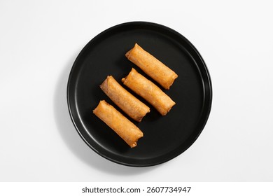 A top down view of a plate of egg rolls.