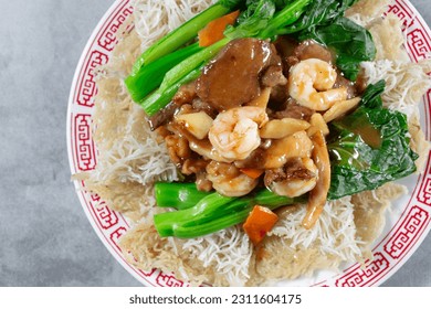 A top down view of a plate of fried vermicelli with beef, chicken and shrimp. - Shutterstock ID 2311604175