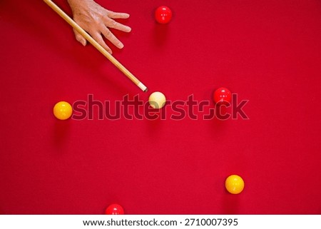 A top down view of a pool table with a cue aiming towards a yellow ball. Billiards and snooker.
