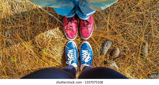 Top Down View Of Red And Blue Shoes Of A Couple In The Nature,