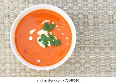 Top Down View Of Red Tomato Soup In White Bowl, Sprinkled With Cream