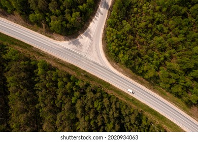top down view of road intersection in the forest at summer, drone shot