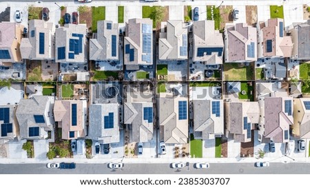 Top down view of a row of residential homes with solar panels on the roof 