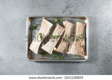 A top down view of several slices of raw beef bone marrow, in a baking sheet.
