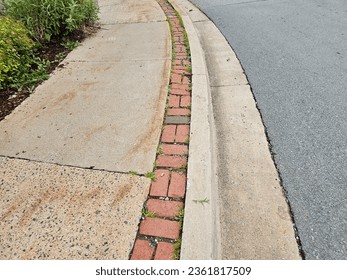 A top down view of a sidewalk with a small brick section along the side of it.