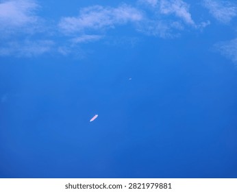 Top down view of a single cargo ship sailing across vast open blue ocean water.