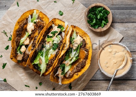 Top down view of smash burger tacos with fresh toppings, ready for eating.