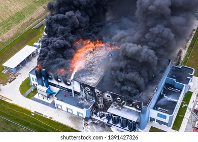 Top down view of smoke clouds from burnt warehouse building with burned roof, fire disaster accident in cargo logistics storehouse