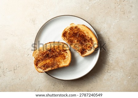 A top down view of some vegemite toast, on a plate.