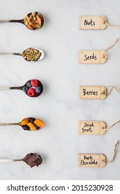 Top Down View Of Spoons Filled With Various Ingredients Used In Making Smoothie Bowls And Trail Mix.