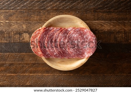 A top down view of a stack of Calabrese salame on a plate.