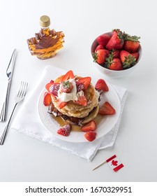 Top Down View Of A Stack Of Pancakes With A Bowl Of Strawberries And A Bottle Of Maple Syrup. Canada Day Concept.