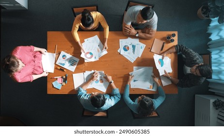 Top down view of start up business team holding paper while discussing about financial idea. Aerial view of smart diverse people brainstorming idea while looking at stock market statistic. Symposium. - Powered by Shutterstock