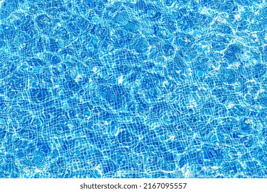 Top Down View Of Surface Of Ripple Blue Water In Swimming Pool With Reflection Of Sun. Swimming Pool Pattern.