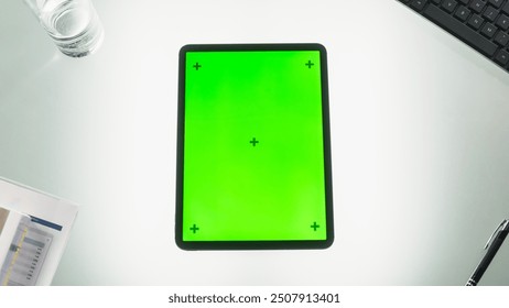 Top Down View of a Tablet Computer with Mock Up Green Screen Chromakey Display with Motion Tracker Placeholders. Picture of a Device on an Office Desk with Business Inventory. Workplace Concept