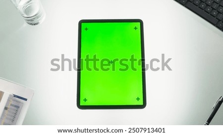 Top Down View of a Tablet Computer with Mock Up Green Screen Chromakey Display with Motion Tracker Placeholders. Picture of a Device on an Office Desk with Business Inventory. Workplace Concept