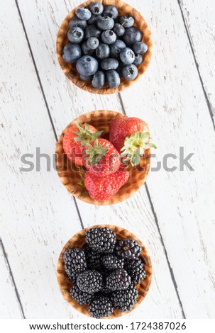 Similar – Image, Stock Photo three ripe blackberries with leaves lie on an old wooden table