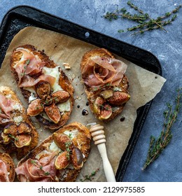 Top down view of toasted fig and prosciutto tartines served with honey. - Powered by Shutterstock