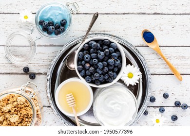 Top Down View Of A Tray Of Ingredients Used In Making A Blue Spirulina Yogurt Parfait.